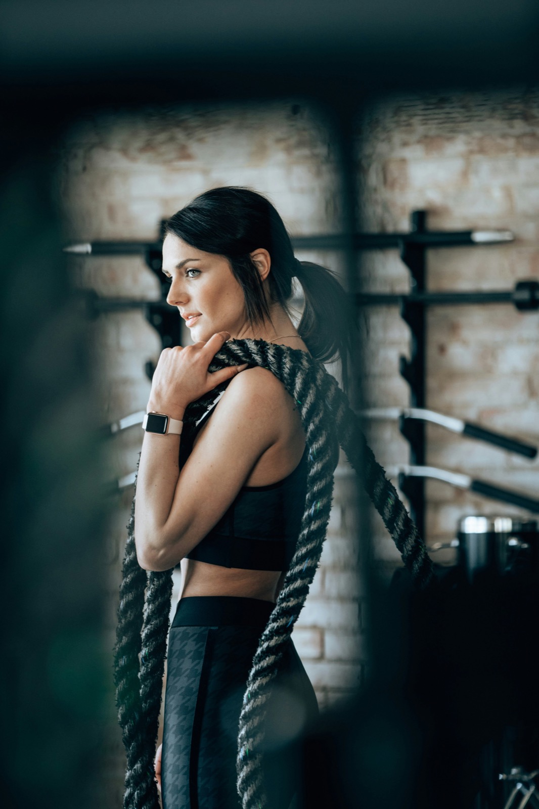 Mujer entrenando con cuerda de batalla, entrenamiento personal 1:1 de Elevate